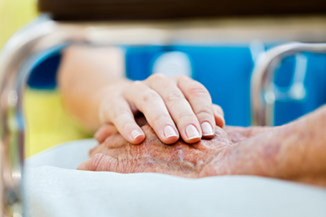 A gentle hand on an elderly person’s hand