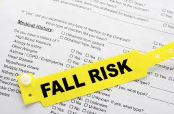 A yellow fall risk label on top of a document