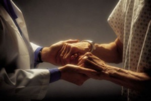 A doctor holding the hands of an elderly person